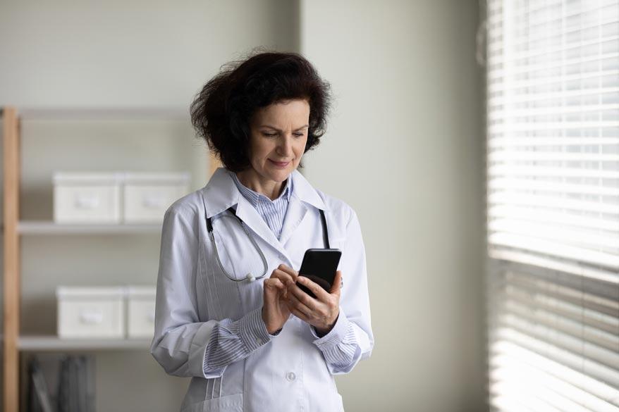 Ärztin schaut auf ihr Smartphone