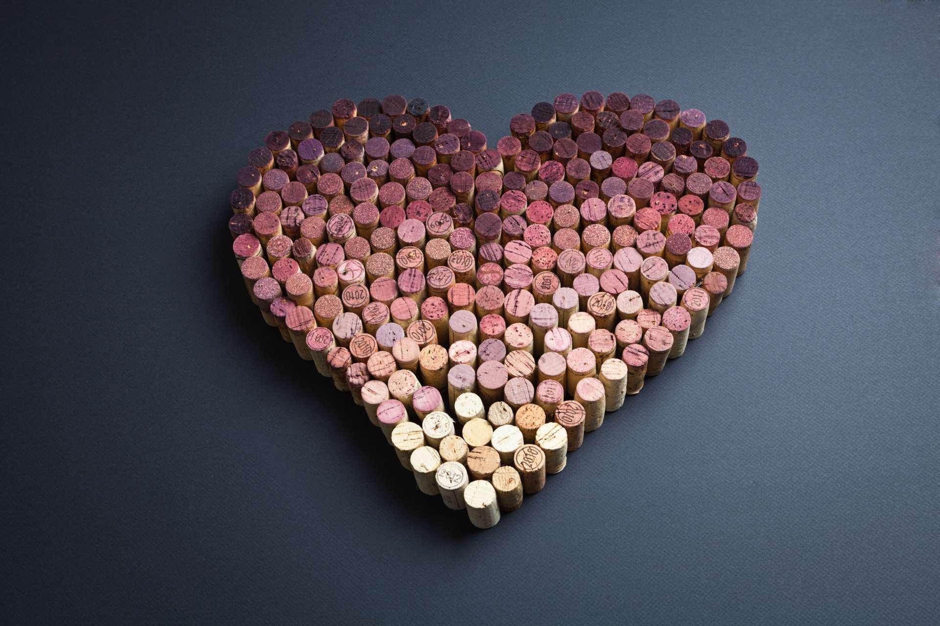 Weinkorken in Herzform auf grauem Hintergrund angeordnet