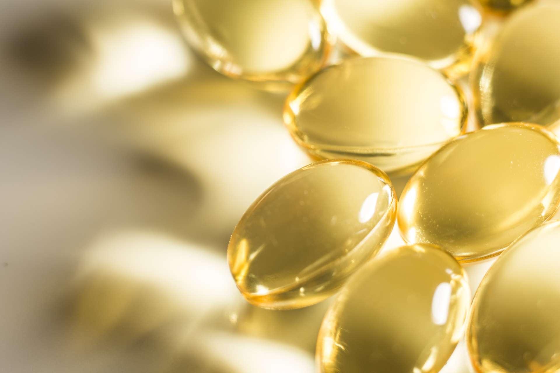 Omega 3 Fischöl transparente Tabletten auf weißer Oberfläche beleuchtet