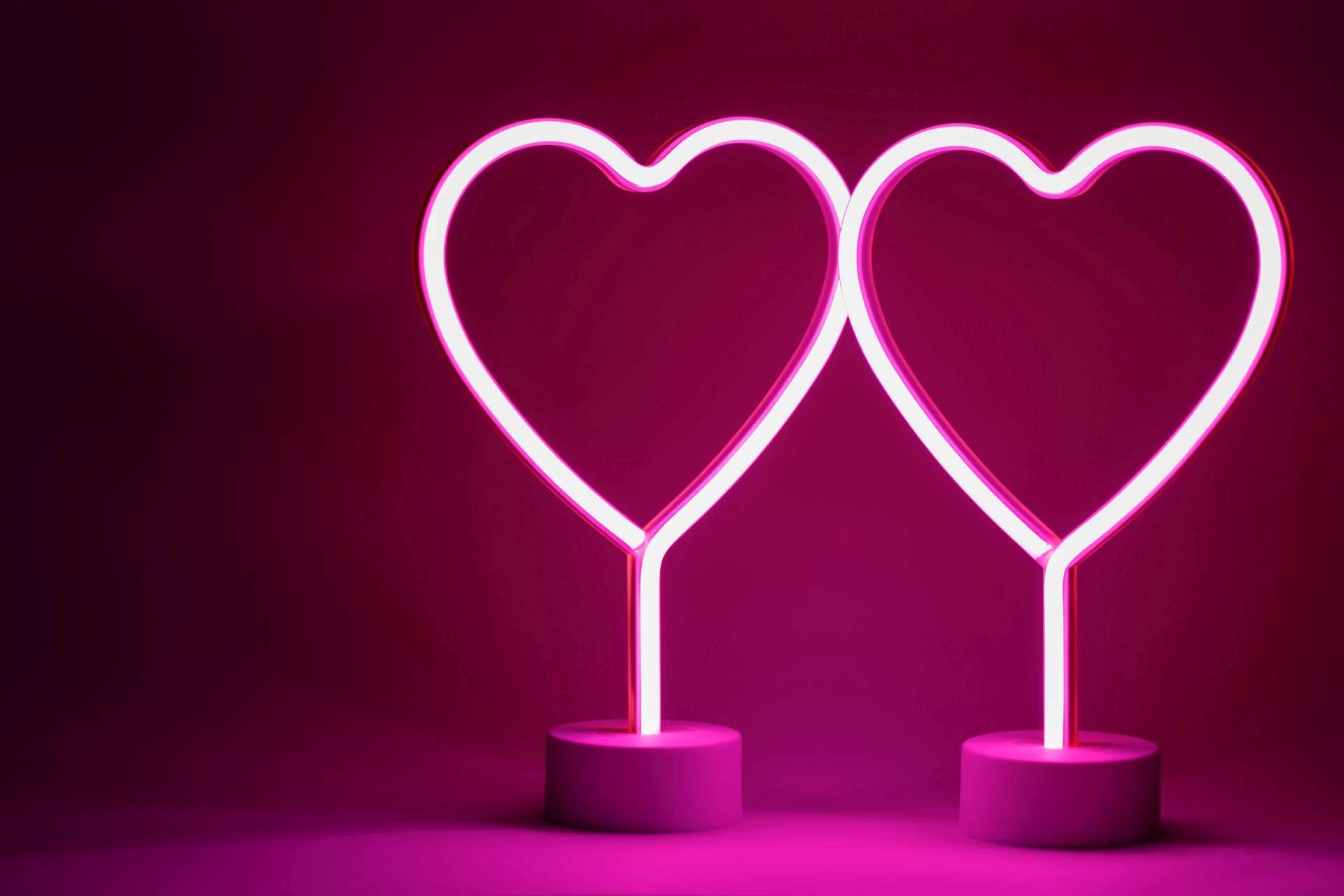 Zwei glühende rosa Neonherzen Valentinstag-Partykonzept
