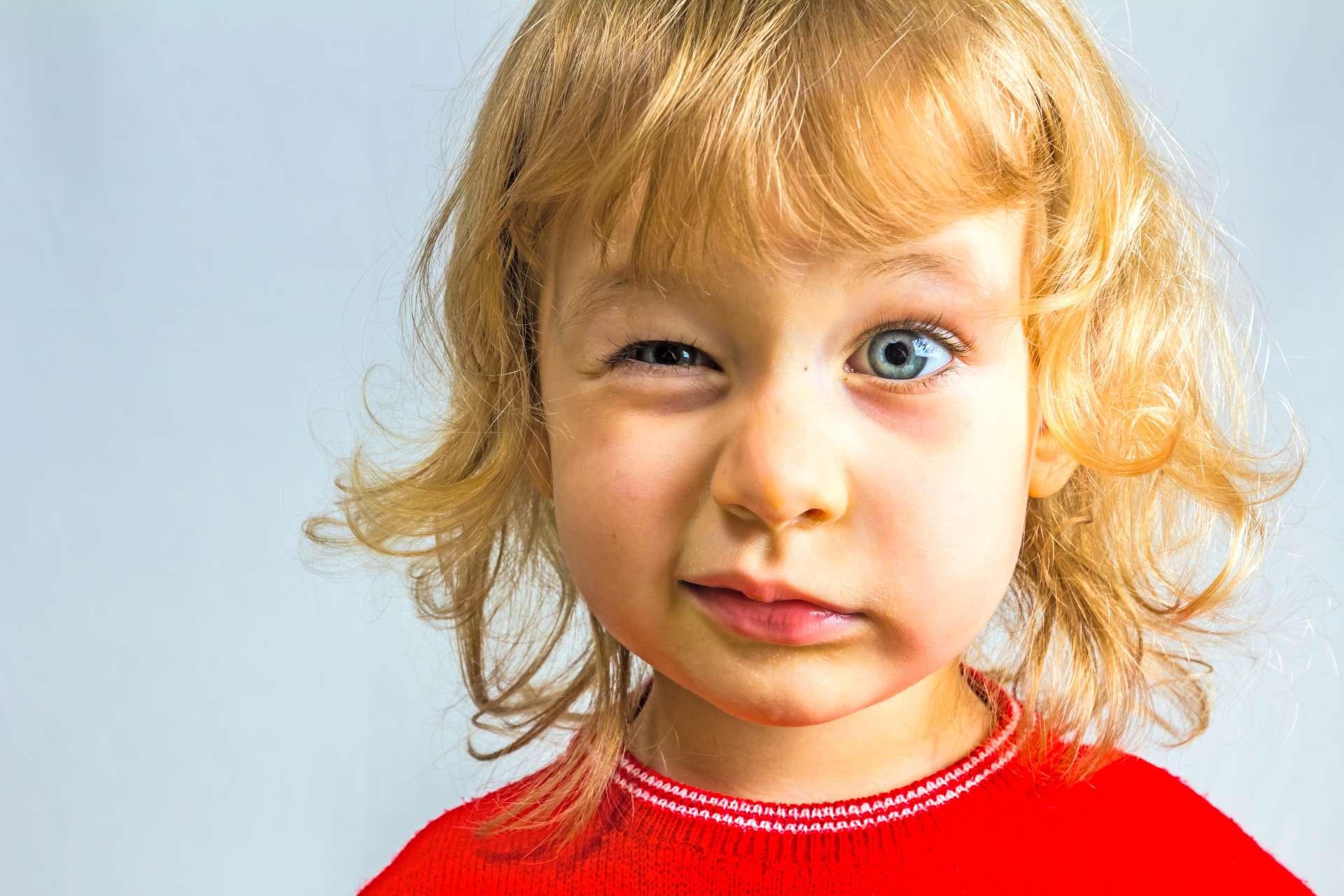 Blauäugiges, 3 Jahre altes Mädchen im roten Kleid