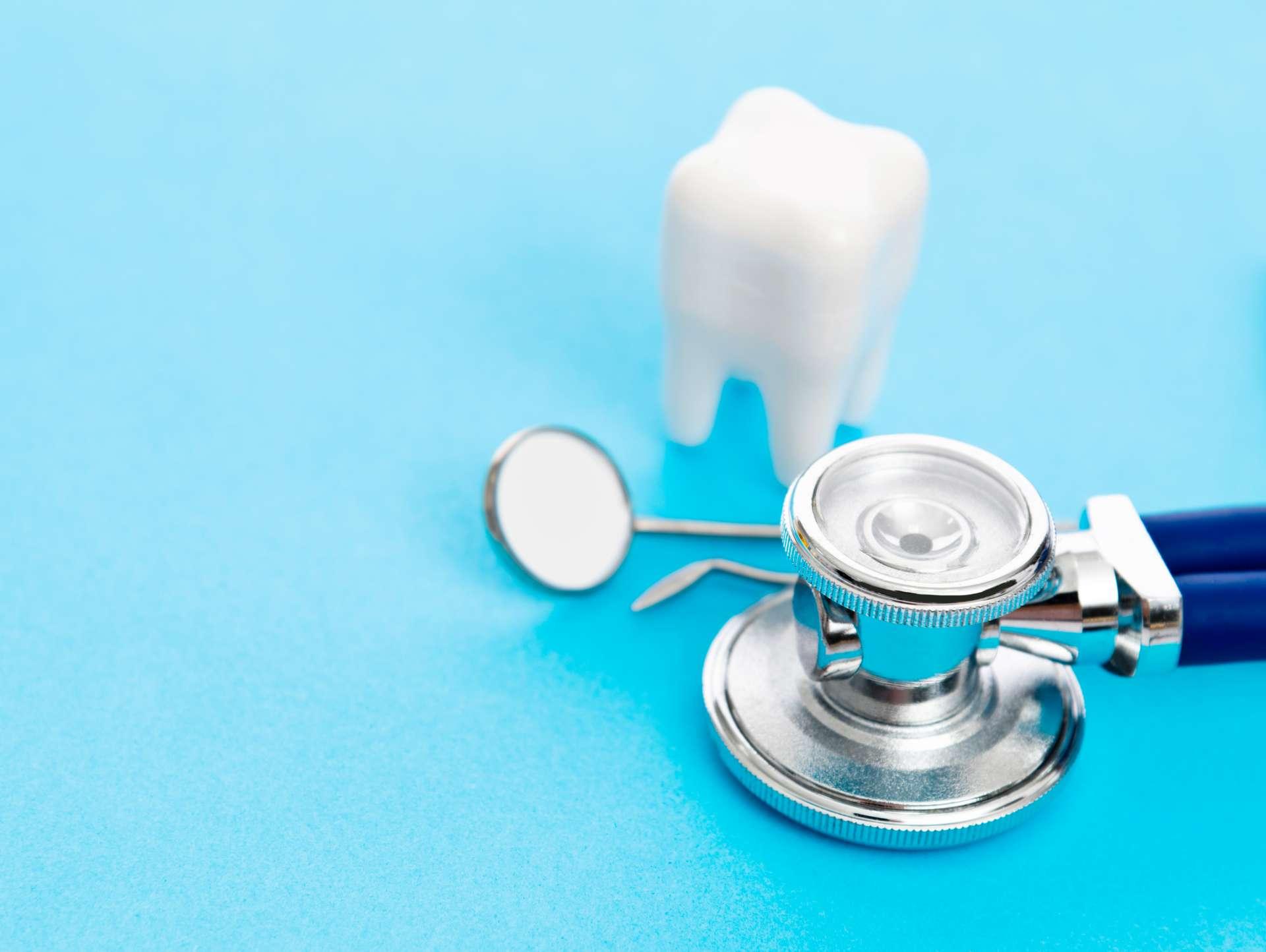 Medizinische Werkzeuge des Stethoskops und des Zahnarztes auf blauem Hintergrund.