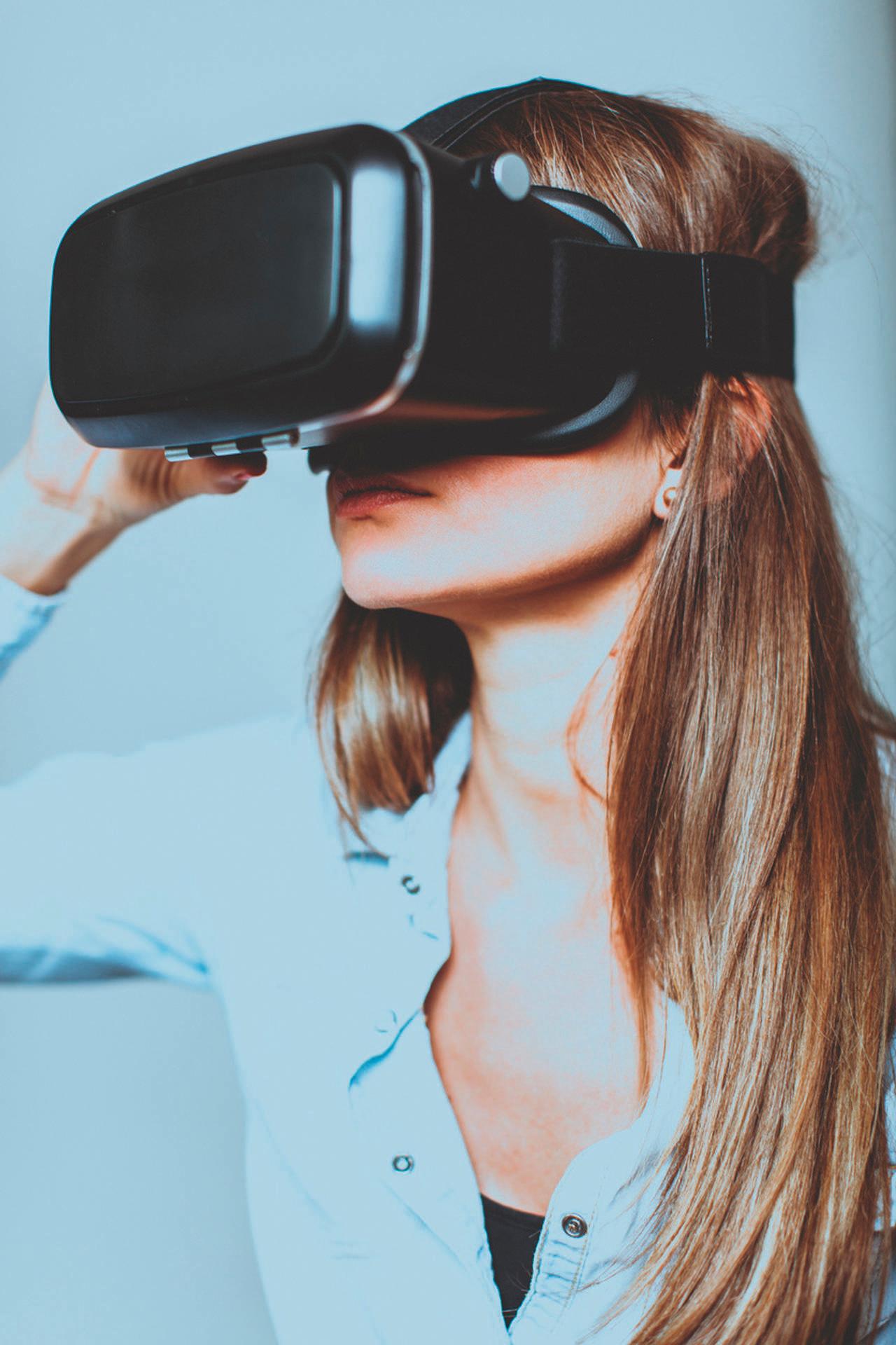 Junge Frau mit Virtual-Reality-Brille; Studioaufnahme, isoliert auf Weiß