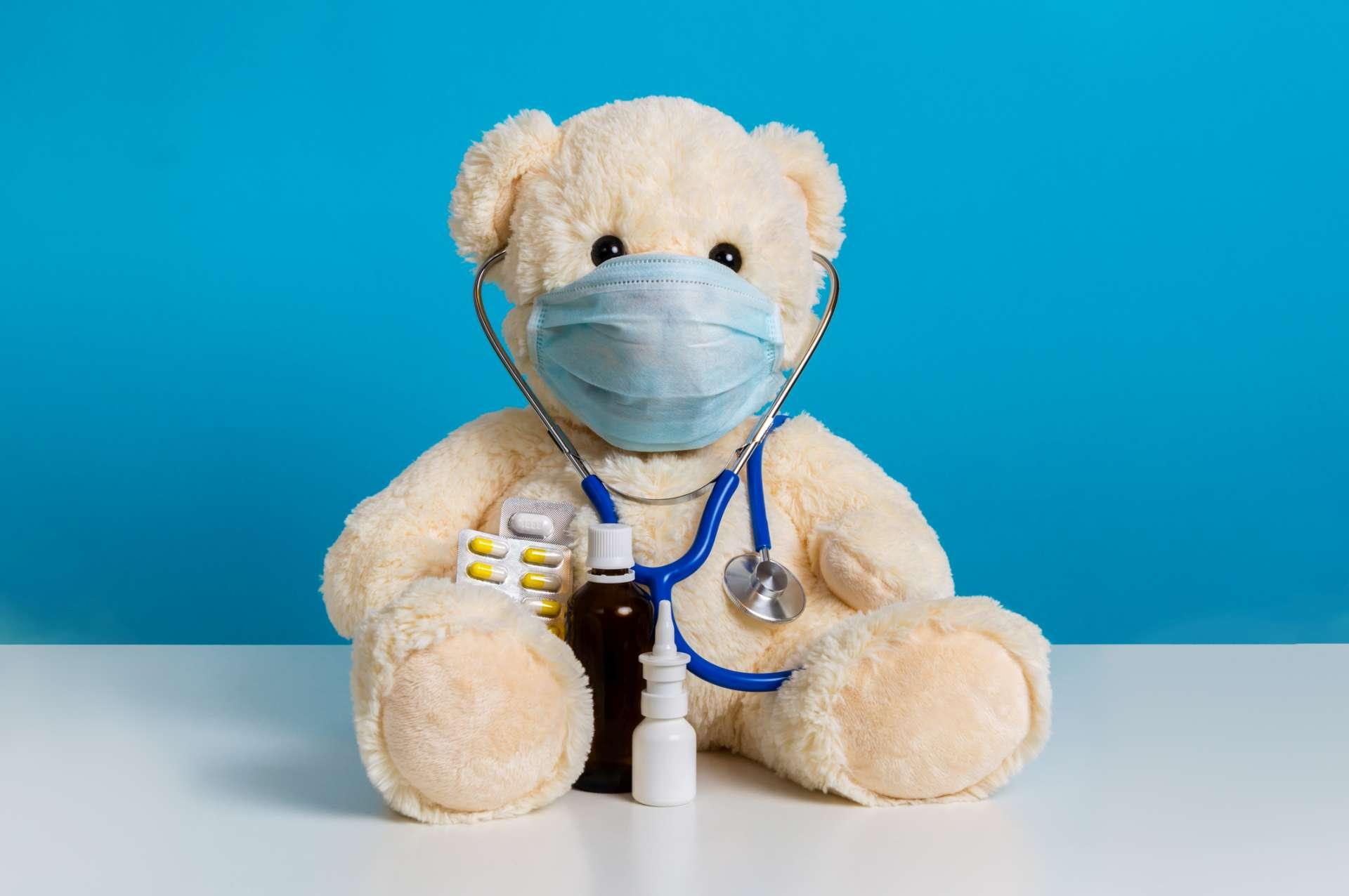 Teddybär Arzt mit medizinischer Maske, Stethoskop und Medizin. Konzept der Hygiene und des Virenschutzes für Kinderpatienten