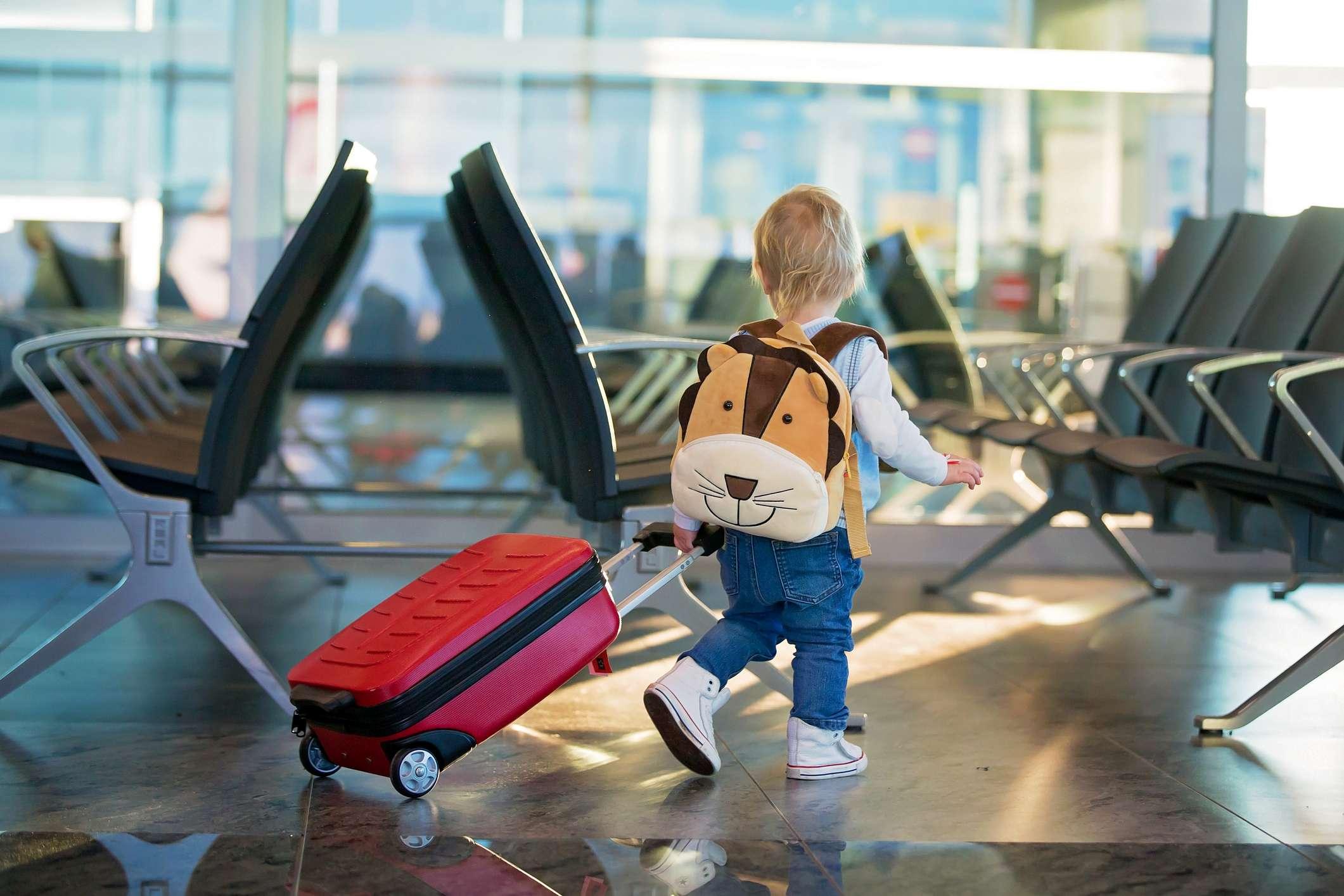 Kinder, die zusammen reisen, am Flughafen warten, um das Flugzeug zu besteigen