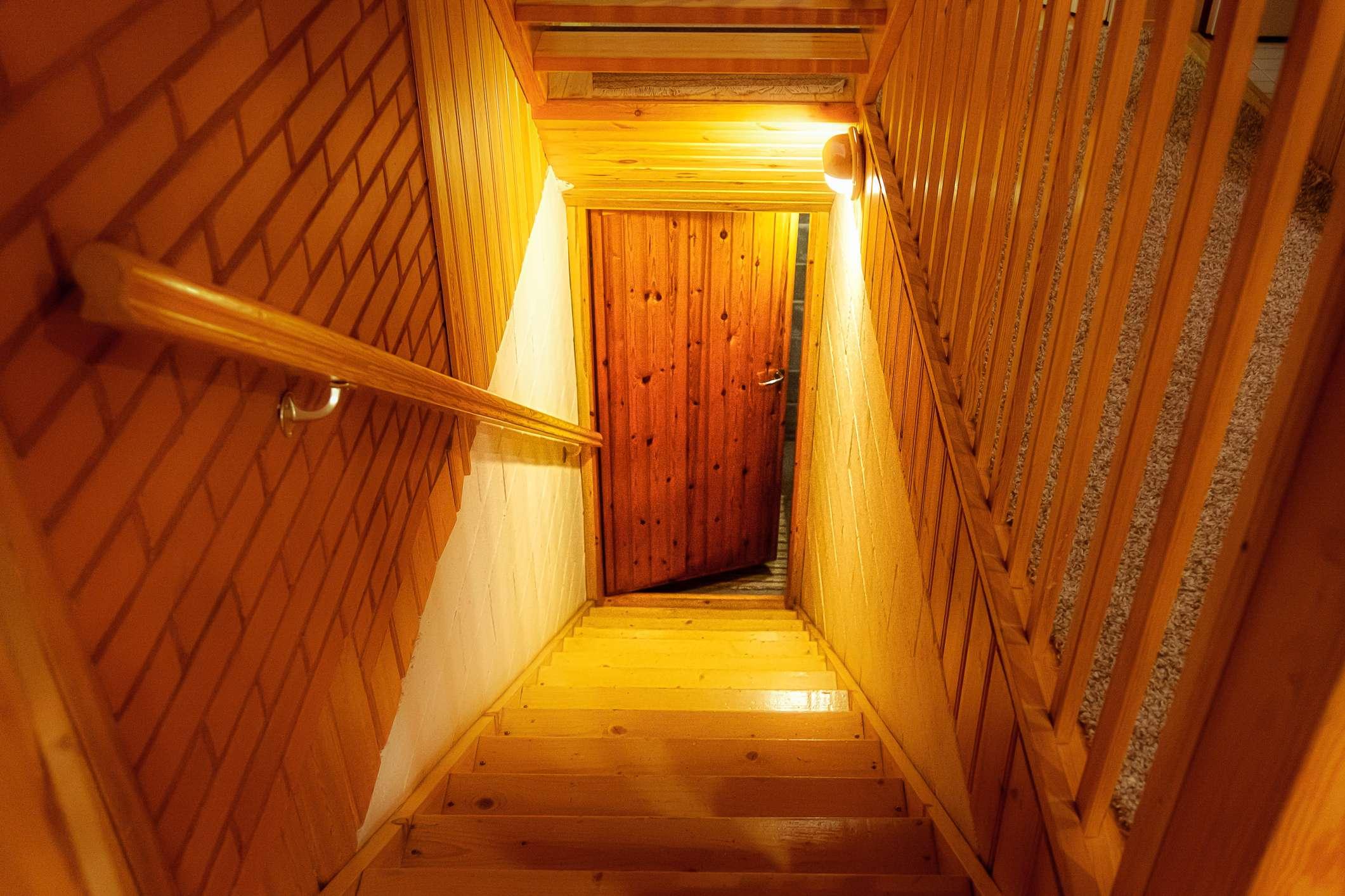 Eine Holztreppe im Haus führt hinunter zur Tür