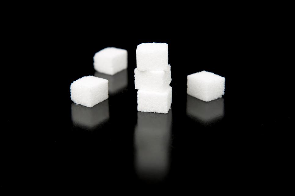 Sugar Cubes with Black Background lying on top and spread out.