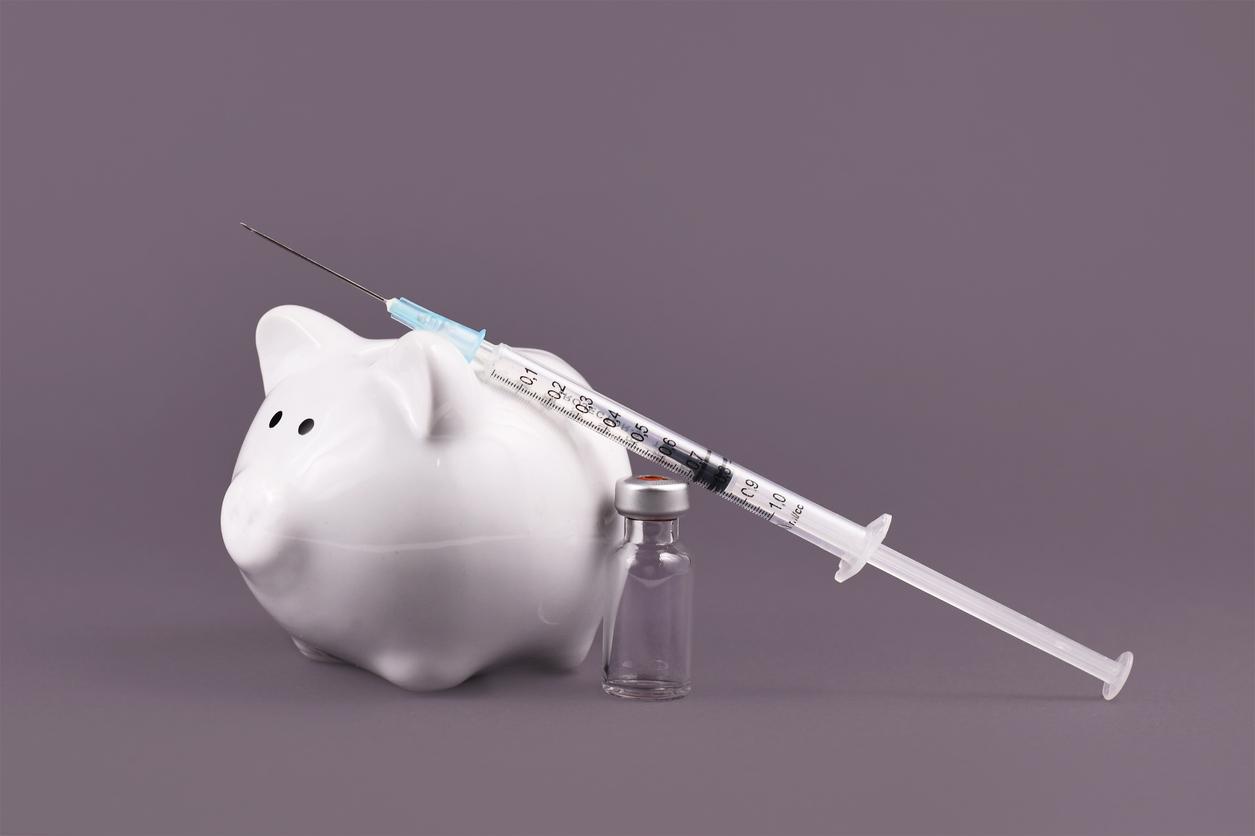 Corona virus vaccination costs concept with syringe, vaccine vial and piggy bank on gray background