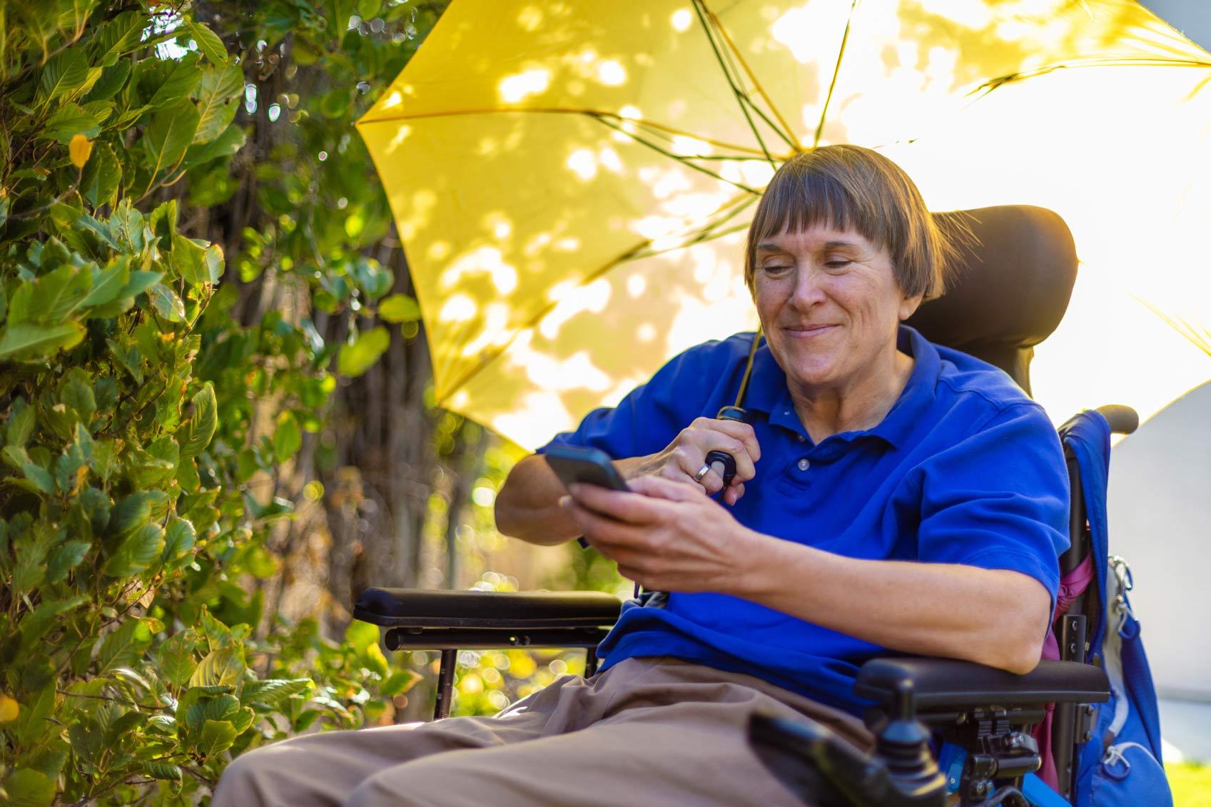 Frau mit einer körperlichen Behinderung durch Multiple Sklerose sitzt im Rollstuhl