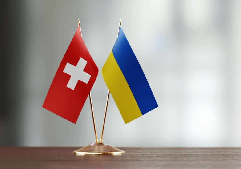 die schweizer flagge und ukrainische flagge auf einem tisch