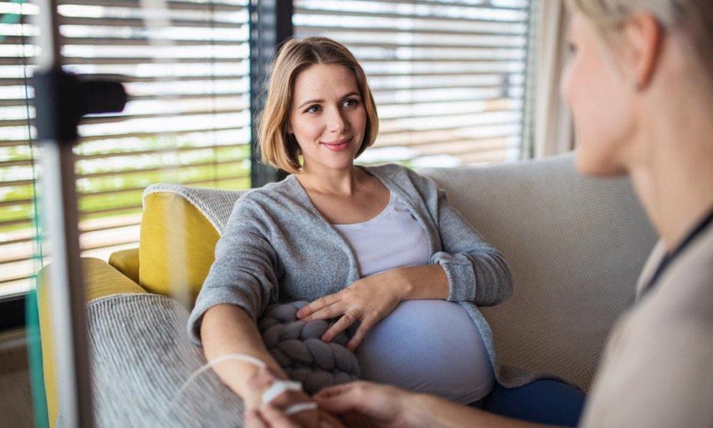 Schwangere Frau wird von Pflegepersonal untersucht
