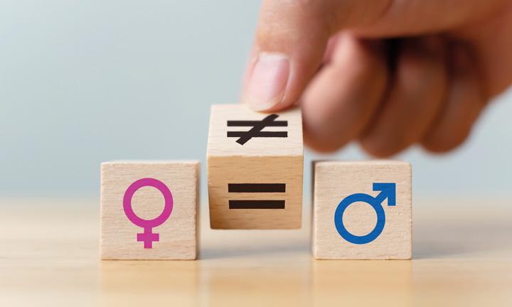 Drei Holzwürfel mit den Symbolen für Frau, Gleich und Mann. Eine dreht das Gleich zu einem Ungleich