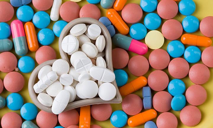 white tablets between colorful heart-shaped medicine