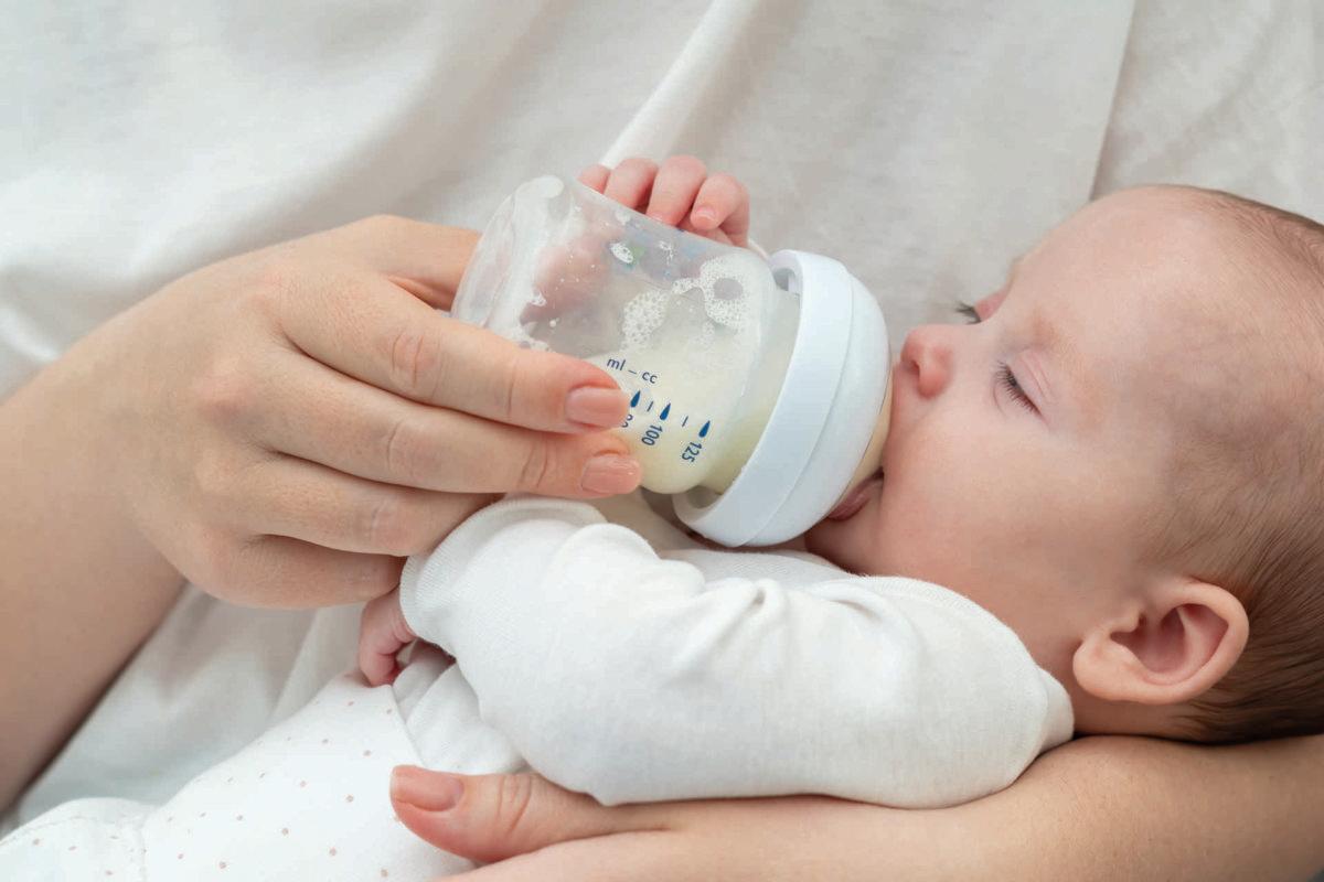 Mother lovingly feeds her newborn with a bottle, highlighting the essence of care and nourishment